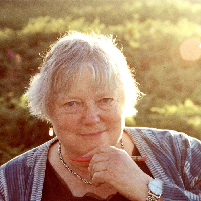 a photo outside in the sun of Dorothy Livingston looking thouoghful with her left hand holding a pencil and resting under her chin
