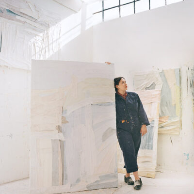 Sarah Marlow Hall shown in her bright painting studio with very large abstract pastel paintings.