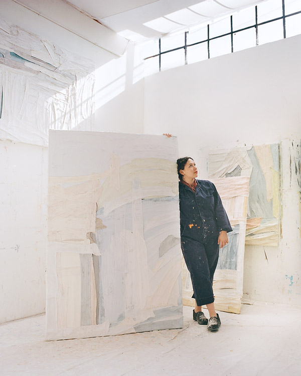 Sarah Marlow Hall shown in her bright painting studio with very large abstract pastel paintings.